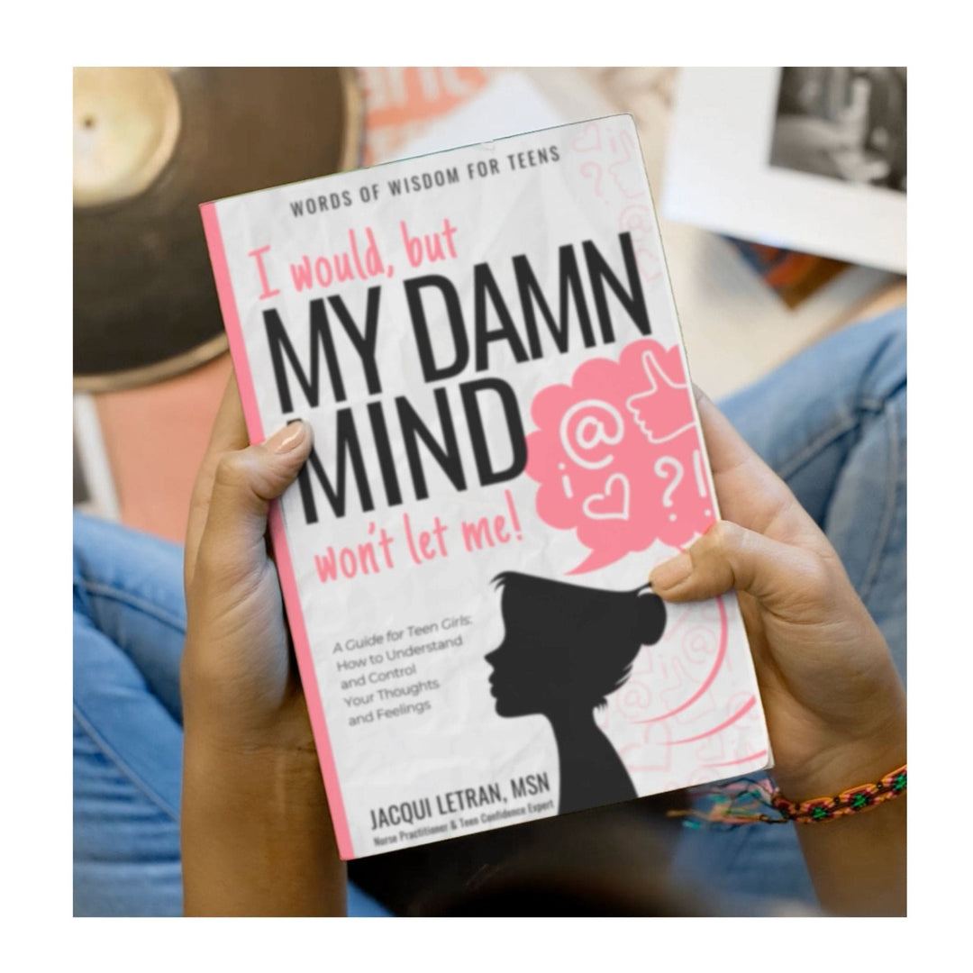 Close-up of the paperback book’s textured cover with vibrant pink and purple hues, revealing detailed grain and embossed