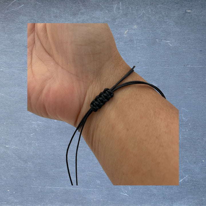 Close-up of the Pinky Promise Bracelet featuring a silver compass charm with engraved details, showcasing fine metalwork and