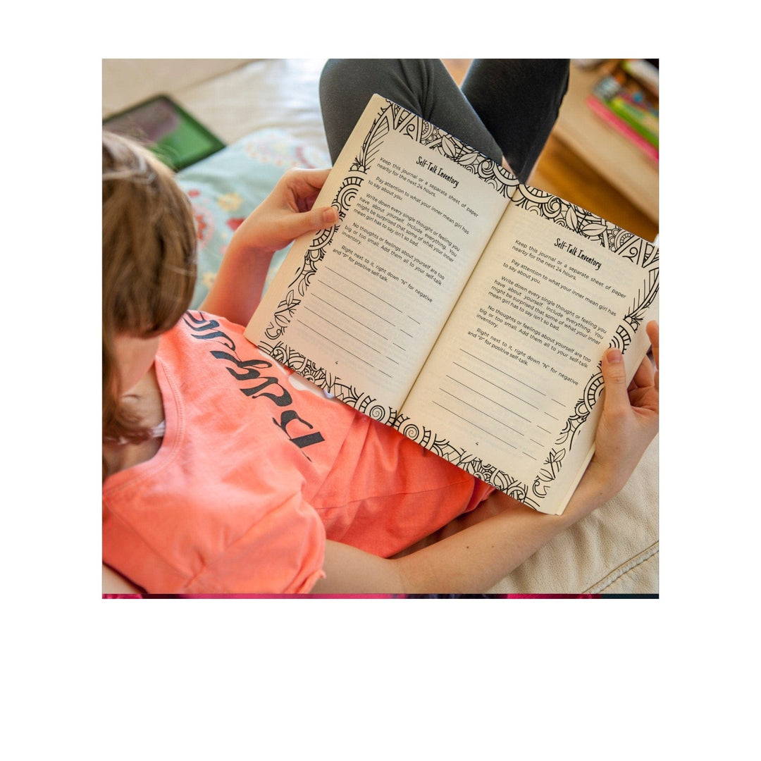 Close-up of the journal’s textured pastel pink cover with embossed floral accents and a gold foil title label.
