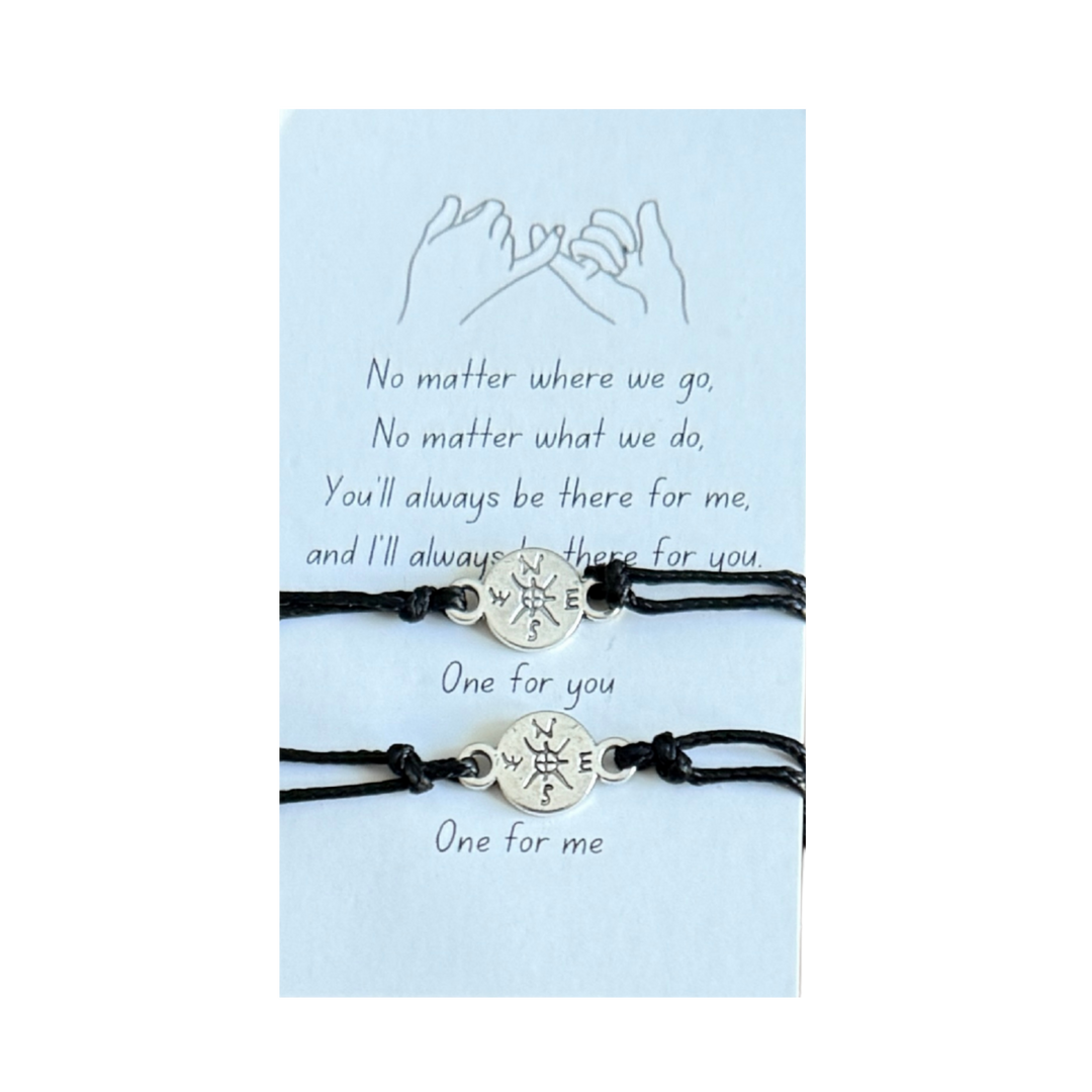 Two black bracelets with compass charms on a light blue card with text, mother daughter bracelets
