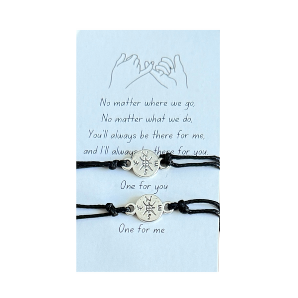 Two black bracelets with compass charms on a light blue card with text, mother daughter bracelets